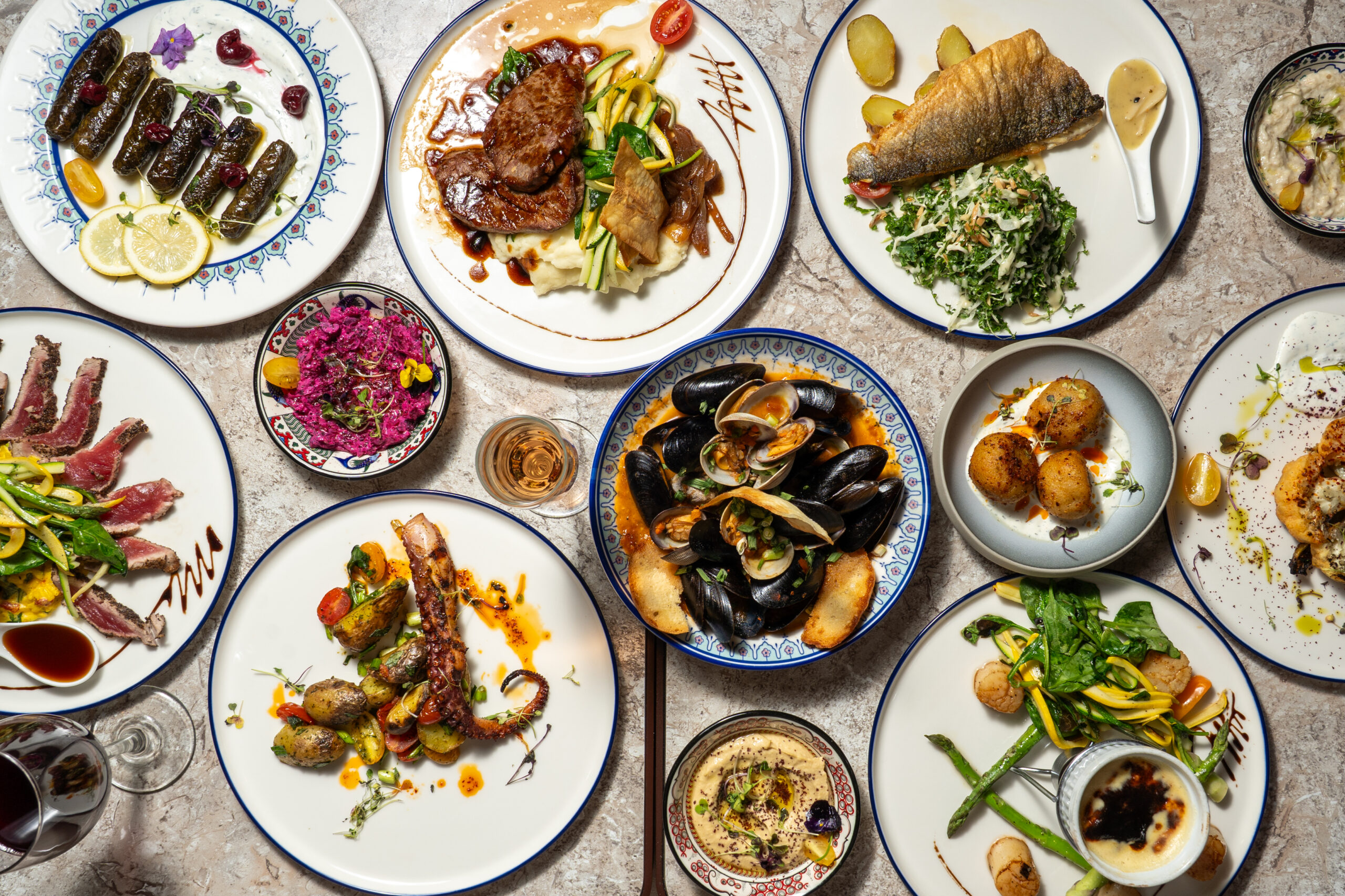 Overhead view of mussels, octopus, filet mignon and branzino at Olivea Restaurant