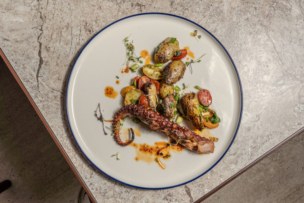 Overhead view of grilled octopus with fingerling potatoes at Olivea Restaurant