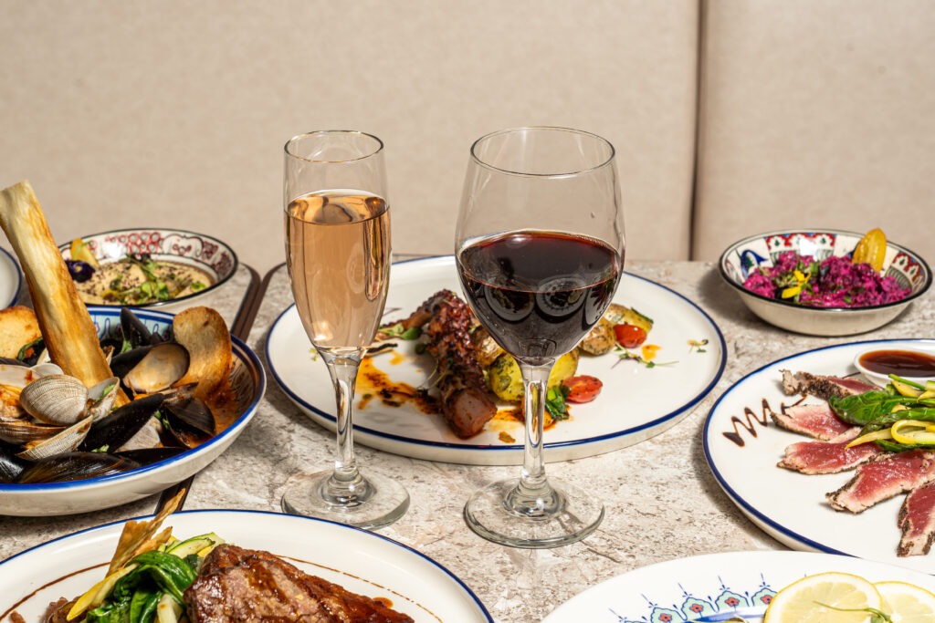 Grilled octopus served with glasses of rosé and red wine at Olivea Restaurant