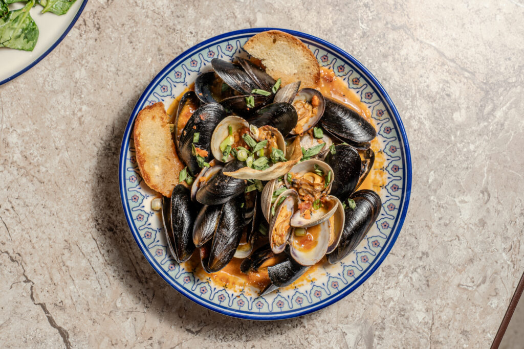Overhead view of PEI mussels and Manila clams with crostini at Olivea Restaurant